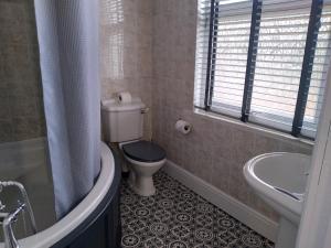 诺廷利Wentvale的浴室配有卫生间、浴缸和水槽。