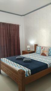 马拉帕斯加ELEN INN - Malapascua Island FAN ROOM #1的一间卧室配有一张大木床和蓝色床单