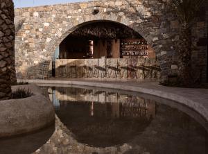 阿齐亚佩拉加Acro Suites - A Wellbeing Resort的建筑前方有水池的石墙