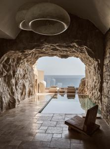 阿齐亚佩拉加Acro Suites - A Wellbeing Resort的一个带游泳池和石墙的房间