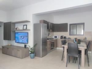 MġarrÉtoile Court Apt - homey, spacious & private patio的厨房配有餐桌和冰箱