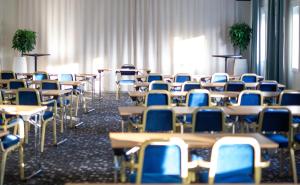 瓦斯泰纳Starby Spa, Hotell & Konferens的一间设有桌椅和蓝色椅子的房间