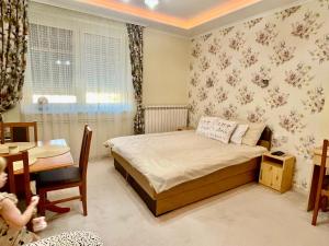 毛科Gita Apartman的一间小卧室,配有床、桌子和儿童