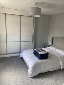 哈德斯菲尔德Huddersfield 2 bedroom house的一间卧室,配有一张带蓝色手提箱的床