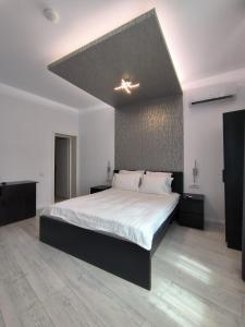布加勒斯特Romana Residence的一间卧室配有一张带白色床单的大床