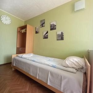 叶尔加瓦Riverside Motel Jelgava的卧室配有一张床,墙上挂着一个钟