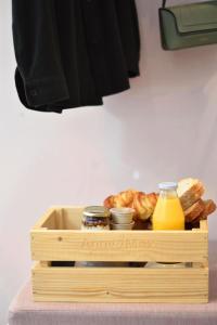 海牙Hotel Bries Den Haag - Scheveningen的装满面包和橙汁的木盒