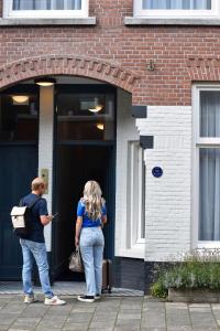 海牙Hotel Bries Den Haag - Scheveningen的站在门外的男人和女人