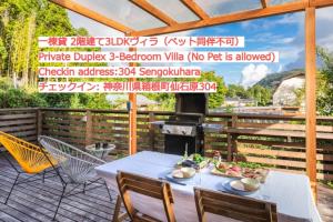 箱根SPRINGS VILLAGE HAKONE Glamping Resort的一个带桌椅和烧烤架的庭院