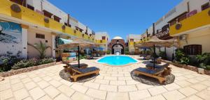 达哈布Delta Dahab Hotel的庭院设有带椅子和遮阳伞的游泳池