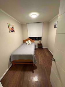 卡拉马Departamento amoblado por dias o meses的铺有木地板的客房内设有一间卧室和一张床。