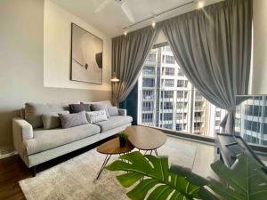 莎阿南Stylish Nordic Suite, Pool View, GEO Bukit Rimau, Kota Kemuning的带沙发和大窗户的客厅