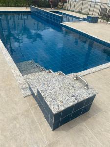 乌贝兰迪亚Ap térreo的一个带蓝色瓷砖地板和小型游泳池的游泳池