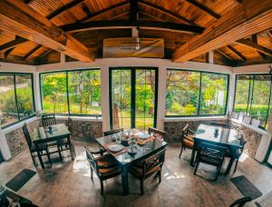 奥希亚Hill Safari - Tea Estate Villa的用餐室设有桌椅和窗户。