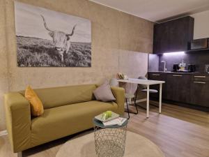 比勒费尔德Urban City Lifestyle Appartement的客厅配有沙发和墙上的牛