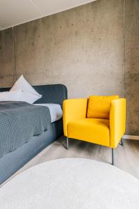比勒费尔德Urban City Lifestyle Appartement的卧室配有黄椅,位于床边