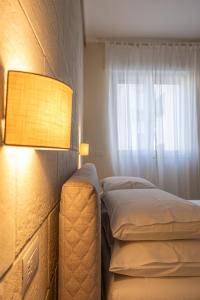 莱切Oronti Accommodations的一间卧室,配有一张床和一个窗户旁边的灯