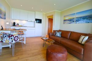 库克斯港Haus Horizont H511的一间带棕色沙发的客厅和一间厨房