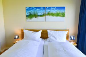 库克斯港Haus Horizont H511的卧室配有2张带白色枕头的床和2盏灯。