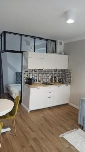 埃尔布隆格Apartament na Starówce的一间厨房,内设白色橱柜和一张桌子