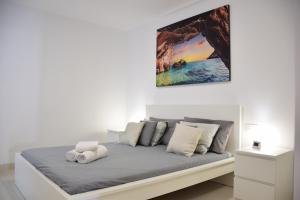 圣胡安海滩Casa Brillante的白色房间一张床上,墙上挂着一幅画