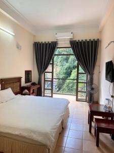三岛县An Phú Motel Tam Đảo的一间卧室设有一张床和一个大窗户