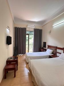 三岛县An Phú Motel Tam Đảo的酒店客房设有两张床和窗户。