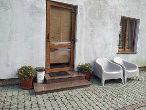 SzackSvitiaz Griada的庭院设有两把白色椅子和一扇门