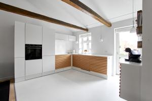 腓特烈西亚Charmerende lejlighed的白色的厨房配有白色橱柜和窗户