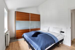 腓特烈西亚Charmerende lejlighed的一间卧室配有一张大床和木制床头板