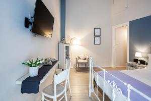 都灵Maison Rêve Torino Centro的一间卧室配有一张床,墙上配有电视