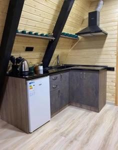 迪利然Cozy Cottage Dilijan Arg的厨房配有白色冰箱和木墙