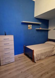 杰拉GelaMare 22的一间卧室设有一张床和蓝色的墙壁