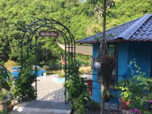 吉婆岛Catba Papillon Garden Bungalows & Resort的绿色植物屋的花园入口