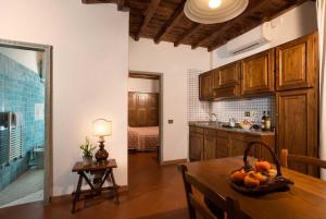 圣多纳托因弗伦萨诺夜莺农场酒店的厨房配有一张桌子,上面放着一碗水果