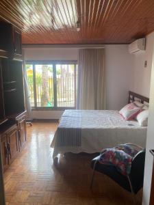 伊瓜苏Quarto em Foz do Iguaçu的一间卧室设有一张床和一个大窗户