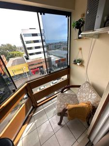 卡庞达卡诺阿Apto 604 vibes的阳台配有椅子和大窗户