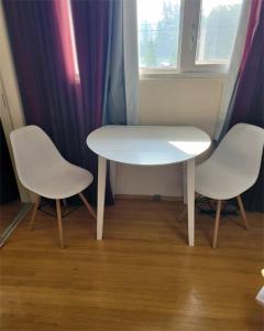 埃德蒙顿The Dewberry Homestay B&B的客房内的一张白色桌子和两把椅子