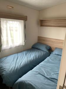 塞尔西Emeralds caravan lettings的一间卧室设有两张床和窗户。