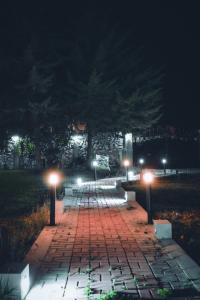 卡哈马卡Redwalls Lodge的夜间带长凳和灯的砖砌走道