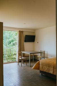卡哈马卡Redwalls Lodge的一间卧室配有桌子、床和窗户
