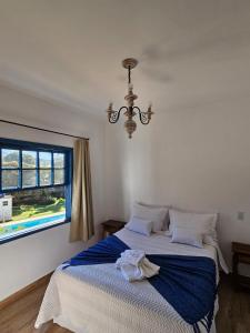 蒂拉登特斯Casa da Tuta Pousada的一间卧室配有一张带蓝色毯子的床和窗户。