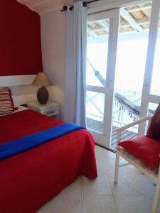 布希奥斯Porto Mar de Búzios的卧室配有床、椅子和窗户。