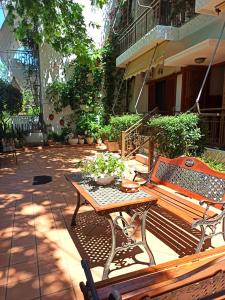 佩弗奇Papadioti Apartments的庭院设有木凳和桌子。
