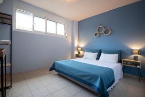 佩雷亚Maisonette PT的一间蓝色的卧室,配有一张大床和两个窗户