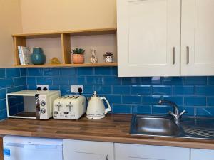 凯尔斯Church View House的厨房柜台设有水槽和蓝色瓷砖