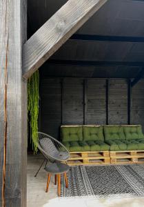 贝茨泰兹瓦赫Bijzonder Lekker overnachten的天井上配有绿色沙发和椅子