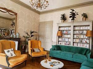 南特Le 1825, une suite luxueuse au coeur de la ville的客厅配有绿色沙发和椅子