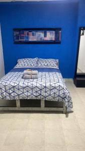 巴拿马城Hostal Cigarra的蓝色的卧室,配有一张蓝色墙壁的床