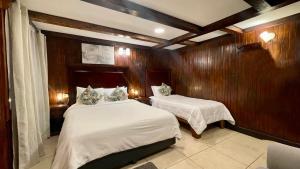 蒙泰韦尔德哥斯达黎加Camino Verde B&B Monteverde Costa Rica的一间卧室设有两张床和木墙